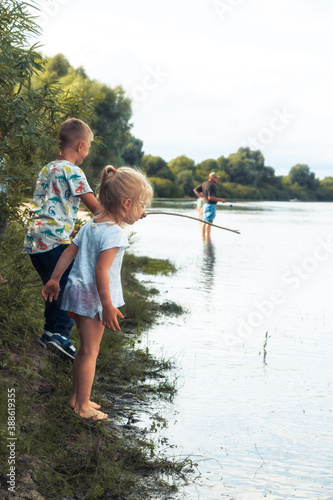 Happy children friends playing together on river bank in countryside concept happy childhood and children curiosity
