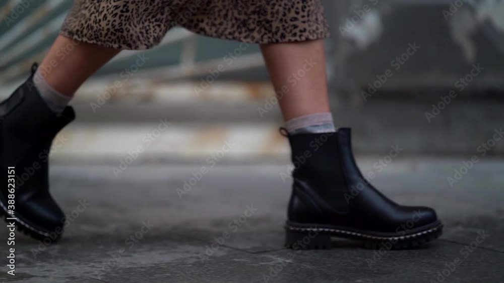 casual style shoes on woman feet, lady is walking at autumn day in city, closeup view on feet
