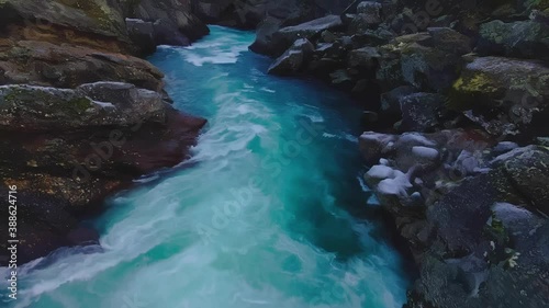 Ice cold glacial water moving through the frozen cliffs and down river. 4K video