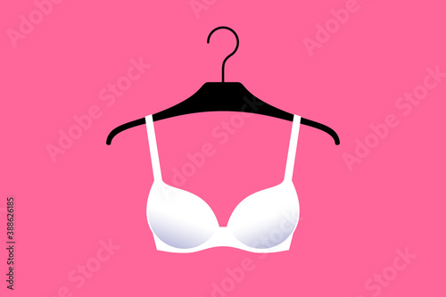 White brassiere is on hanger over bright pink background