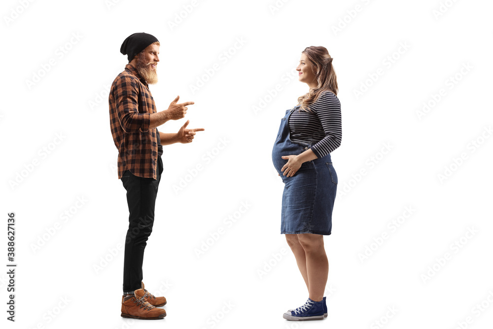 Full length profile shot of a bearded guy standing and talking to a pregnant woman Full length profile shot of a bearded guy standing and talking to a pregnant woman