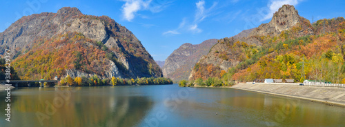 Olt Gorges panorama in a sunny autumn day. Olt river entering a mountainous canyon formed by sharp cliffs and mountain peaks. Autumn foliage. Carpathia, Romania.