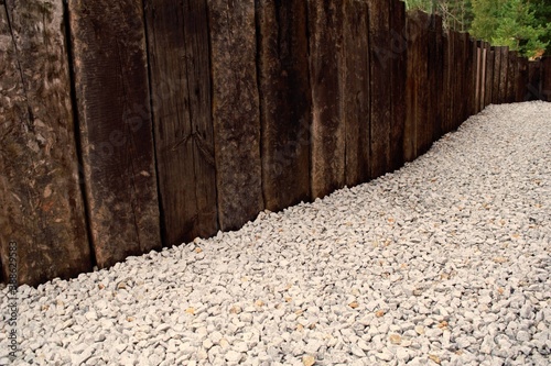 Arrangement of the space around the house in the form of a wooden fence and small white pebbles. photo