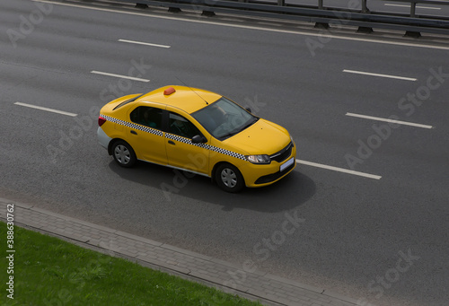 Yellow Taxi Drives on the City Street © Yuri Bizgaimer