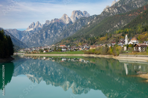 Rocky Dolomites and idyllic town overlooking emerald Lago di Santa Caterina.
