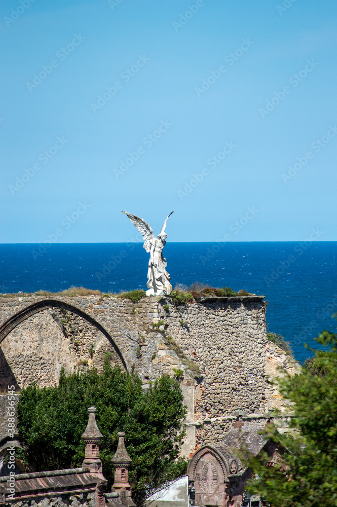 Statue of an angel at the cemetery of Comillas, Spain Statue of an angel at the cemetery of Comillas, Spain