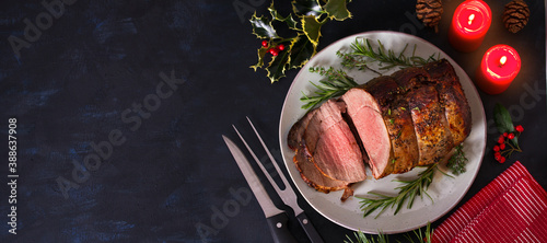Roasted beef. Christmas decorations. New Year dinner table. View from above, top studio shot, copy space