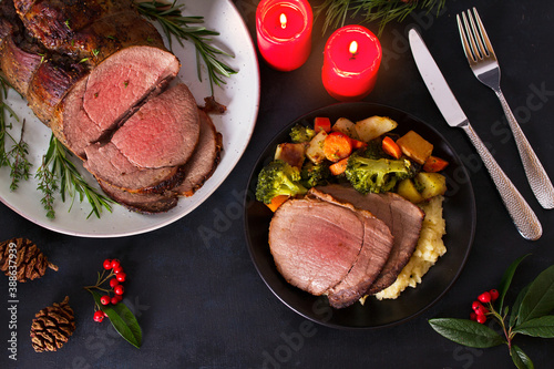 Roasted beef. Christmas decorations. New Year dinner table. View from above, top studio shot