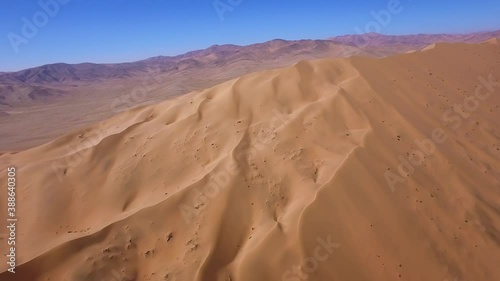 Aerial landscape shot of the golden dry sand of the Atacama desert, bright sunlight. photo