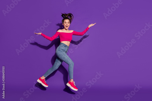 Full length body size view of pretty carefree slender cheerful girl jumping running isolated over bright violet color background
