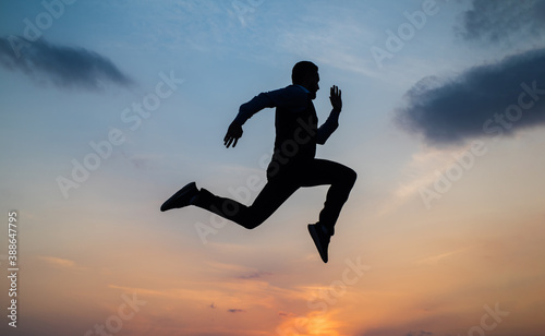 Find your freedom. personal achievement goal. man silhouette jump on sky background. confident businessman running. daily motivation. enjoying life and nature. business success. freedom