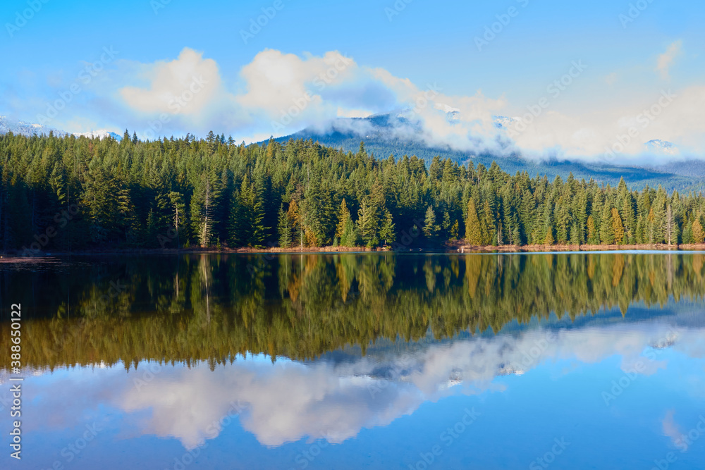 Reflection of trees and mountains on the lake in Whistler, Canada