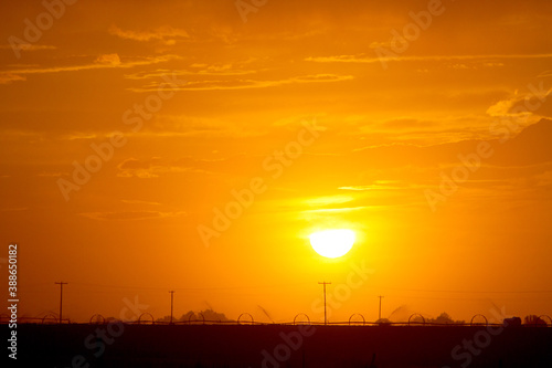 A farmland silhouette over a beautiful sunset.
