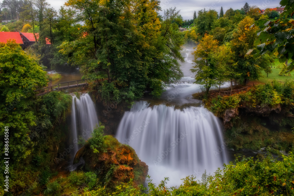 Waterfall Veliki Buk - Big Buk in green nature of Korana river, village of Rastoke, Slunj, Croatia. August 2020. Long exposure picture.