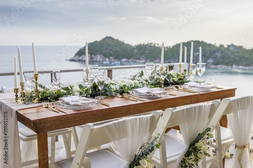 Romantic Wedding Table Top Layout Table Spread no people tropical location with gold cutlery and scenic view of sunset with copy space