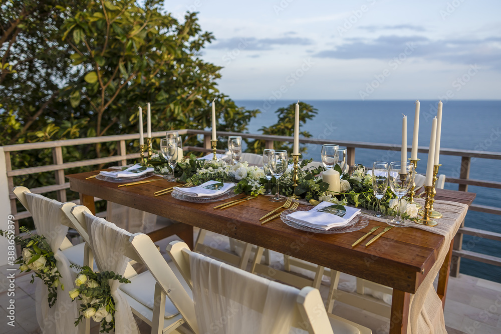 Romantic Wedding Table Top Layout Table Spread no people tropical location with gold cutlery and scenic view of sunset with copy space