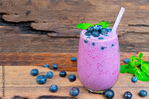 Blueberry smoothie purple colorful fruit juice milkshake blend beverage healthy high protein the taste yummy In glass drink episode morning on wooden background.