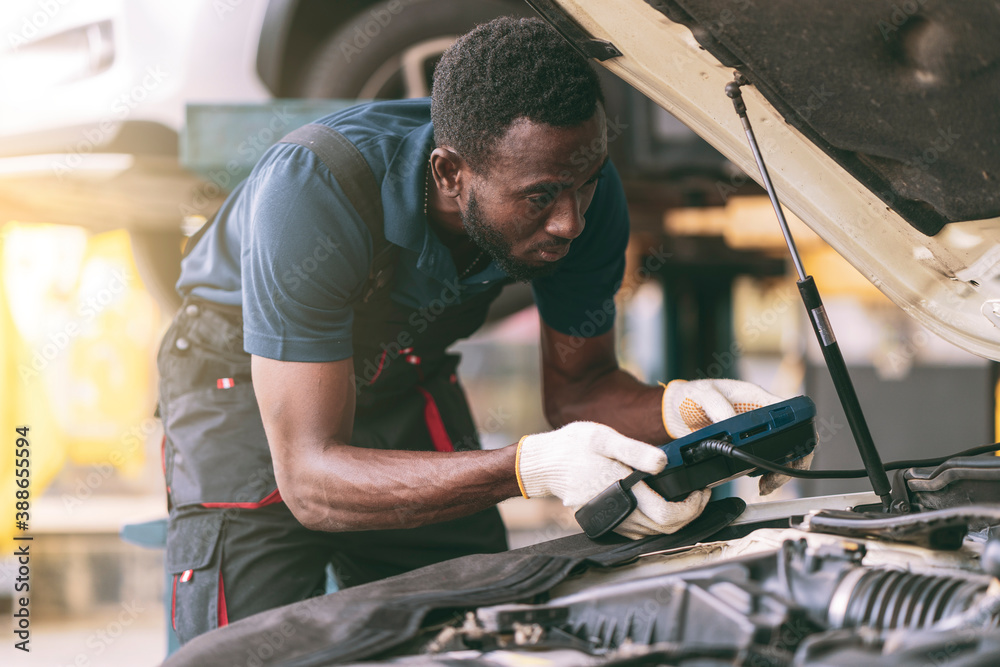 Auto mechanic working in garage, car repair services Auto mechanic working in garage, car repair services