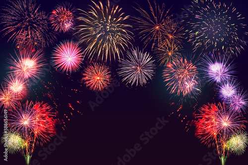 Bright colorful fireworks background. Happy New Year and celebration concept.