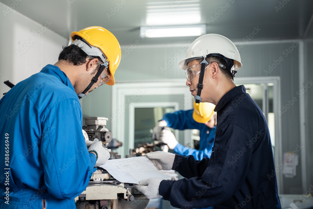 Asian engineer man training his worker for process of heavy machine. Asian engineer man training his worker for process of heavy machine.