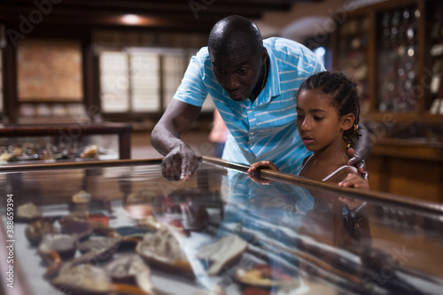 African American father and daughter looking at stands with exhibits at historical museum