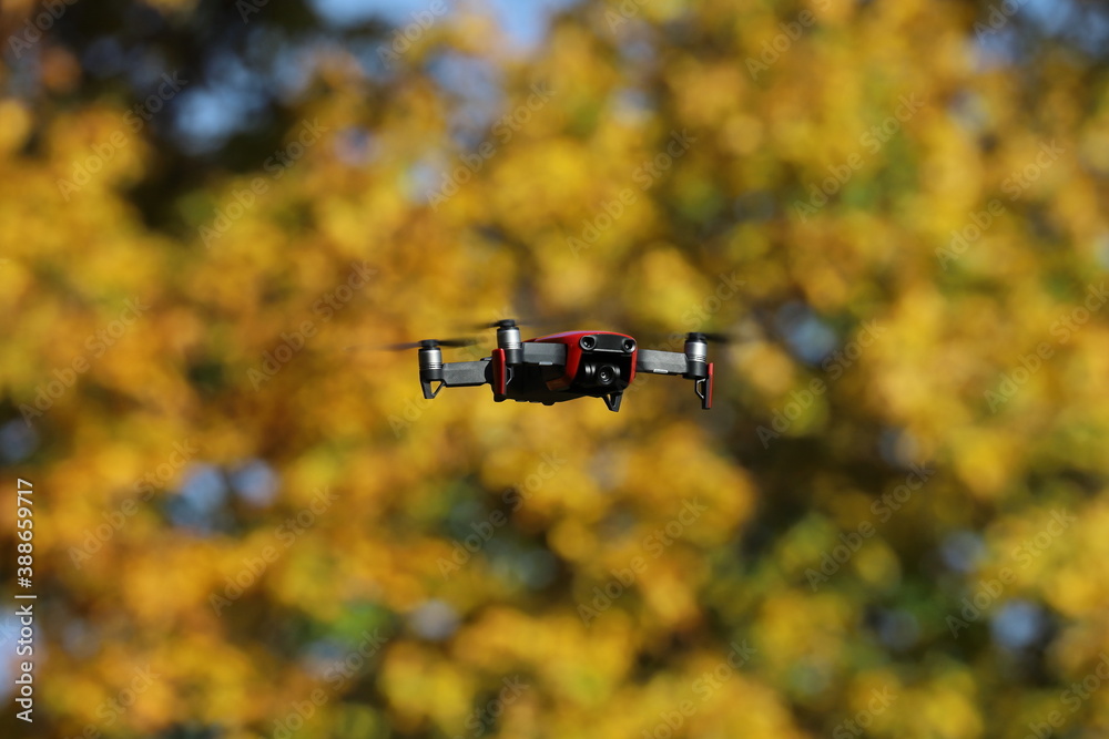 drone in flight against the backdrop of autumn trees drone in flight against the backdrop of autumn trees