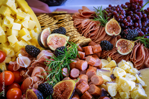 Fototapeta Naklejka Na Ścianę i Meble -  Cheese, fig, and crackers on charcuterie board .