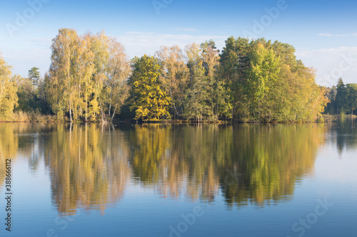 Nature rural pond water in autumn landscape Beautiful lake in the background of colorful forest. Romantic place for holidays. Romantic reflection. 