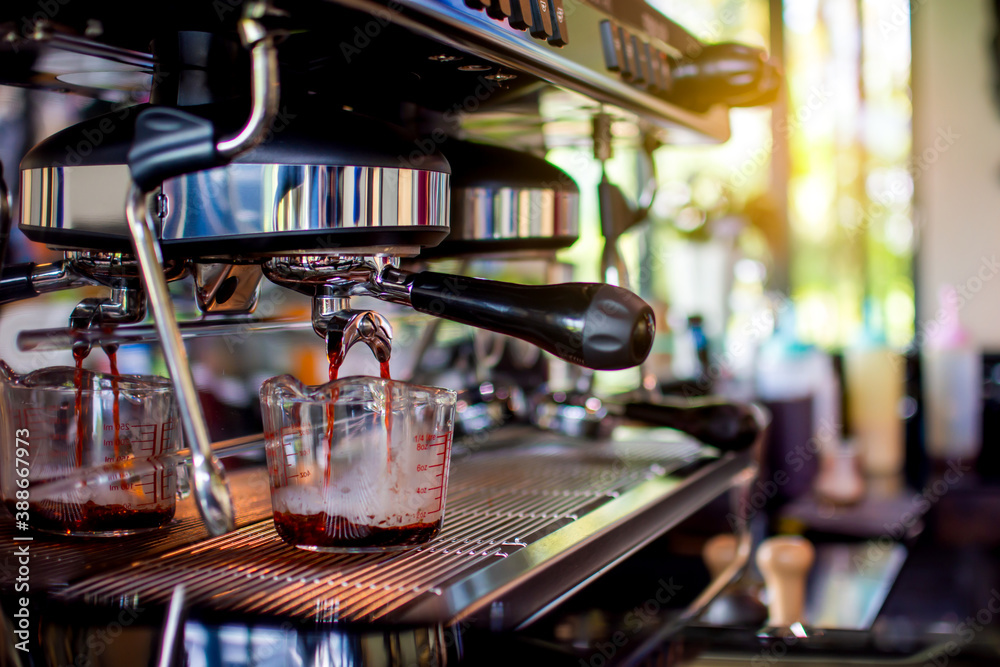 Extraction of coffee from a professional coffee machine at the coffee shop in the morning. Extraction of coffee from a professional coffee machine at the coffee shop in the morning.