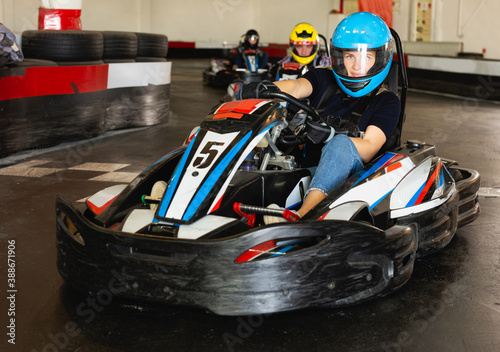 Man and women competing on racing cars at kart circuit