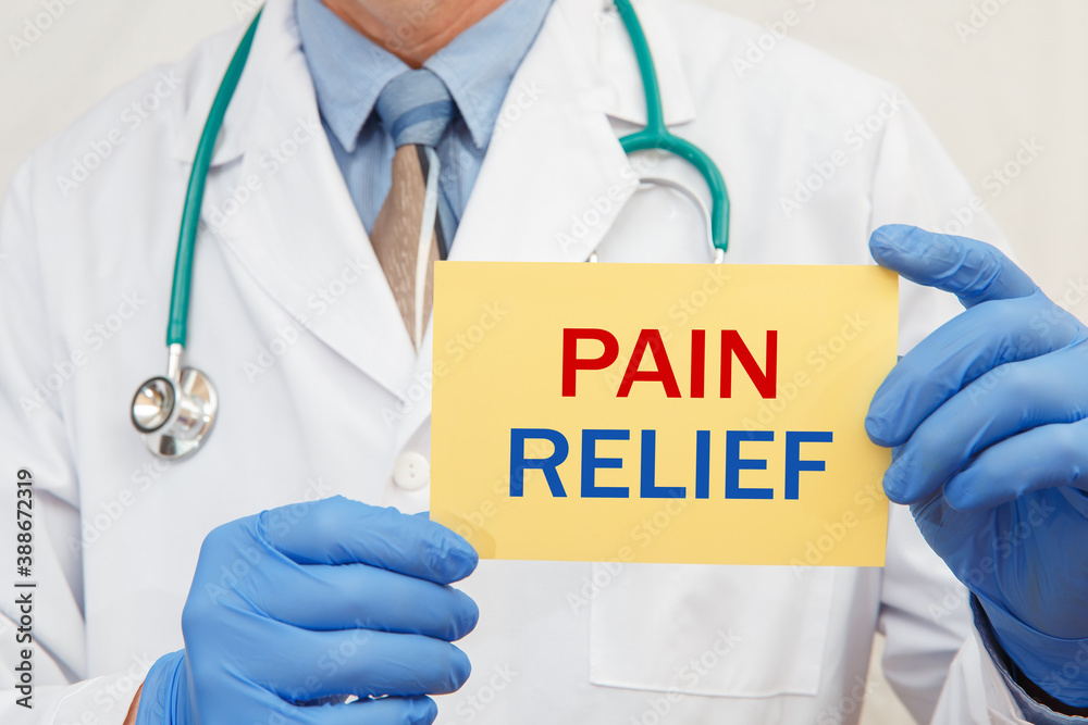 Close-up of a male doctor holding a sign with the text PAIN RELIEF Close-up of a male doctor holding a sign with the text PAIN RELIEF