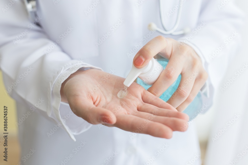 The female doctor sat using alcohol gel to wash her hands The female doctor sat using alcohol gel to wash her hands