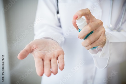 Cleaning hands with sanitizer alcohol spray.