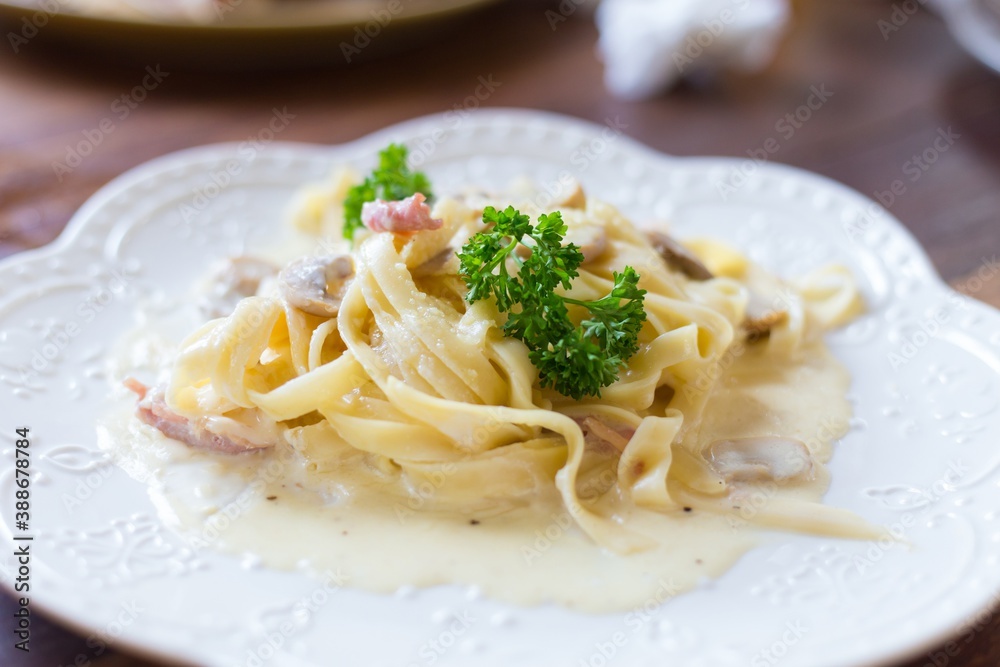 Spaghetti mushroom cream sauce with bacon on white dish, italian pasta