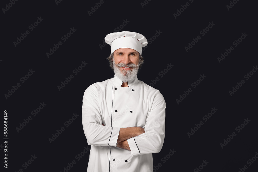 Mature male chef on dark background Mature male chef on dark background