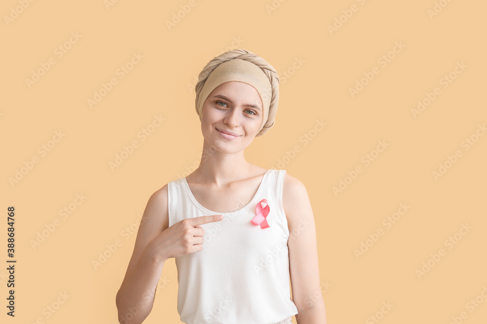 Woman after chemotherapy with pink ribbon on color background. Breast cancer awareness