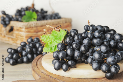 Board with sweet ripe grapes on table