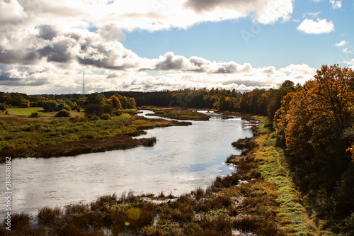 Countryside view of river Venta flowing near forest in autumn.