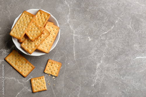 Foto Delicious crispy crackers on grey table, flat lay. Space for text