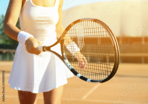 Sportswoman playing tennis at court on sunny day, closeup © New Africa
