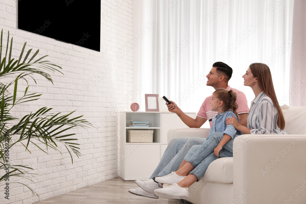 Happy family watching TV on sofa at home Happy family watching TV on sofa at home