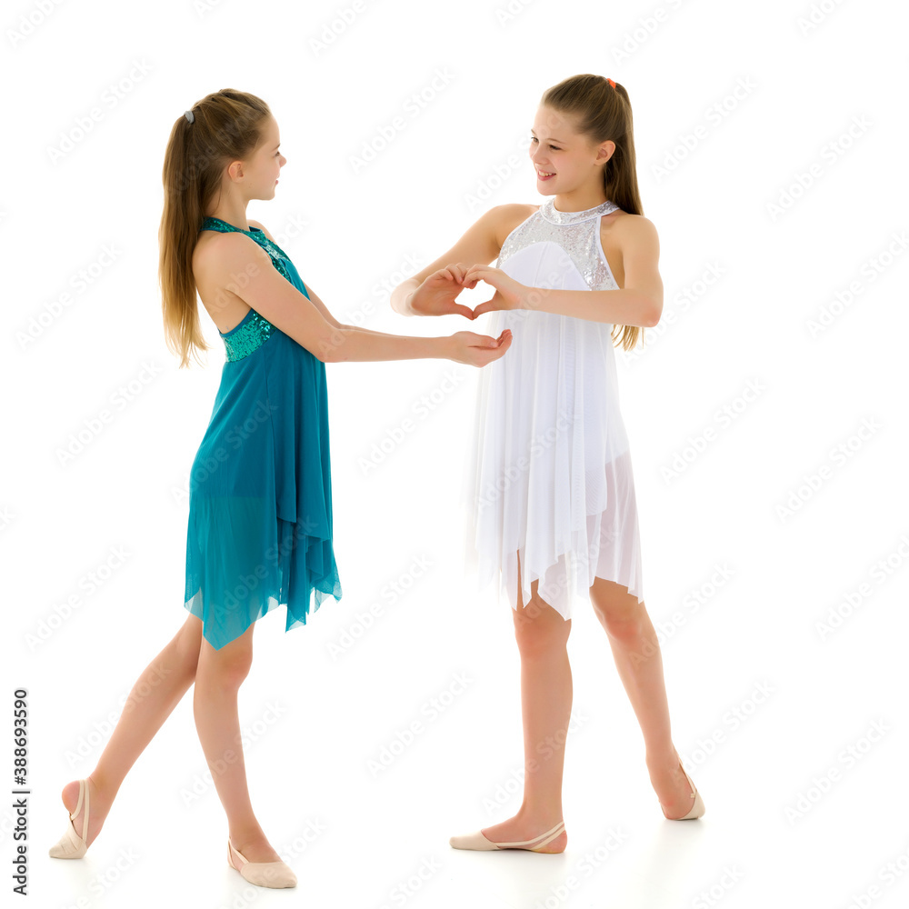 Two adorable girls gymnasts folded palms in the shape of a heart Two adorable girls gymnasts folded palms in the shape of a heart