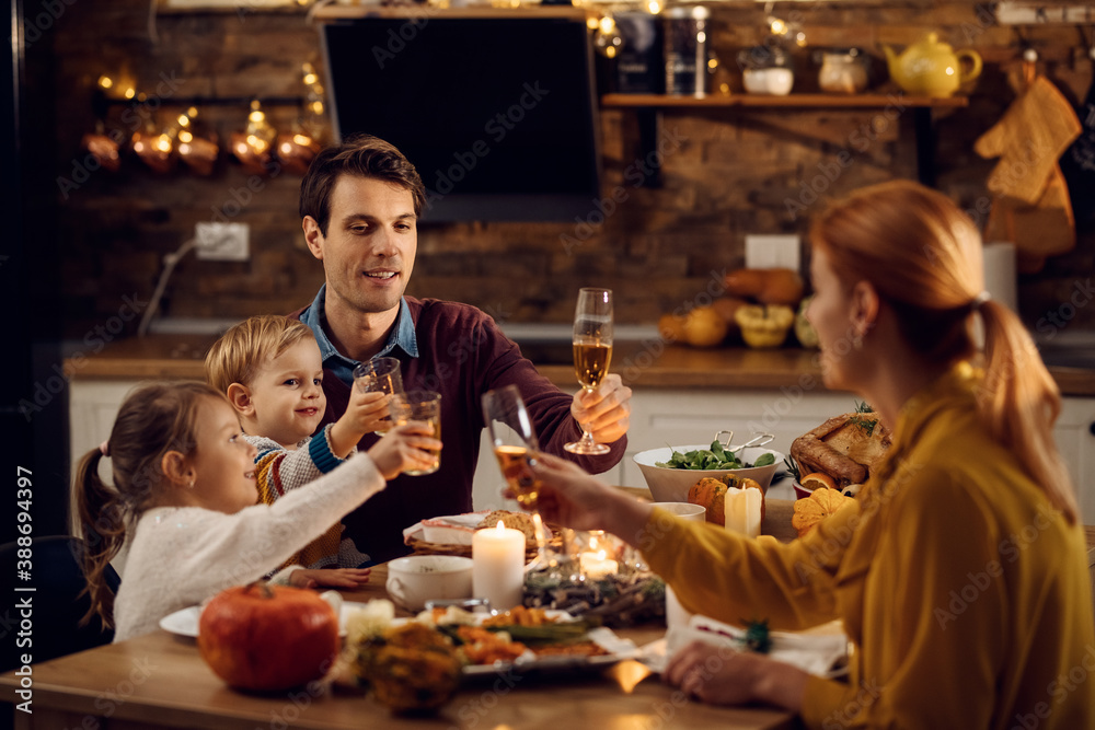 Happy family toasting during Thanksgiving meal in dining room.