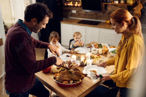 Happy family enjoying in Thanksgiving dinner in dining room.