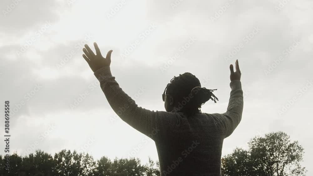 Scared Afro-American man holding hands in the air and surrendering.