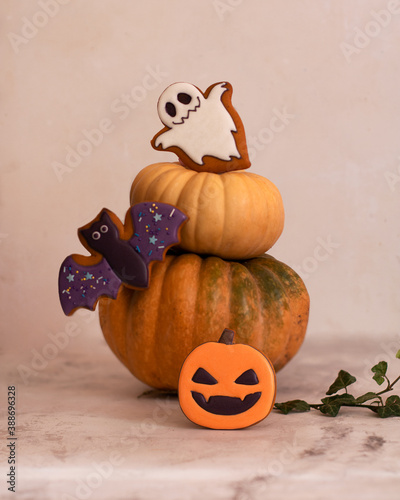 Gingerbread in the style of Halloween. Ghost, pumpkin, bat. High key. Light photo. Wooden background. copy space. Vertical orientation
