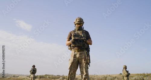 Fotografía Soldiers protecting commander while surveilling enemy territory