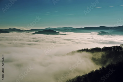 Panorama with a  foggy valley at Hungarian mountain range with sunlight. 