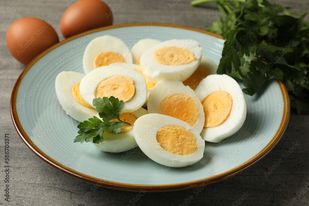 Plate with boiled eggs and parsley on gray background Plate with boiled eggs and parsley on gray background