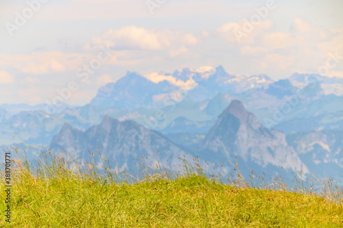 Beautiful view from a mountain in Switzerland. The sky has perfect contrast with the grass field in the front.